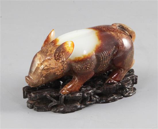 A Chinese archaistic white and brown jade figure of a standing pig, 9.6cm, with carved wood stand and fitted box